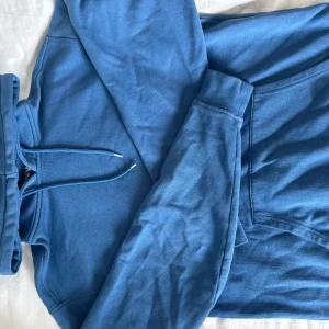 Blå hoodie från WINWIN - Säljer en blå hoodie från WINWIN i storlek M. Tröjan har huva med snörning, känguruficka och långa ärmar. Mjuk insida och klassisk passform, perfekt för chill dagar. Färgen är en snygg mellanblå nyans.