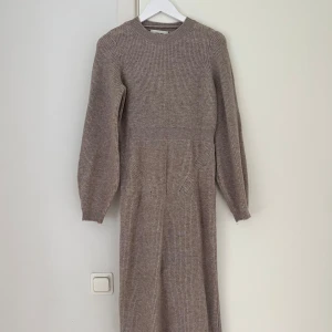 Beige stickad klänning - Stickad beige långklänning med en slits bak. Liknande som den från Adoore. Passar även som storlek M. Aldrig använt. Köpt på Vero Moda 🤎