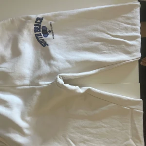 Vita mjukis byxor från Gina - Vita mjukisbyxor med blått tryck och texten 'Padel Sports Club' framtill. Mjukt material och avslappnad passform, säljer dessa då dem tyvärr inte passade mig i längden. Skulle säga att de passar perfekt för 170cm