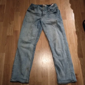 Ljusblå Levis jeansbyxor Low Taper - Säljer ett par ljusblå Levis jeansbyxor med klassisk femficksdesign och Levis-logga på bakfickan. Modellen är Low Taper med normal passform och raka ben. Perfekta för en avslappnad stil och till Grischare och dom me avslappnad stil. Storlek 164-172. Kolla profilen för mer grisch kläder och fotbollströjor bland annat.