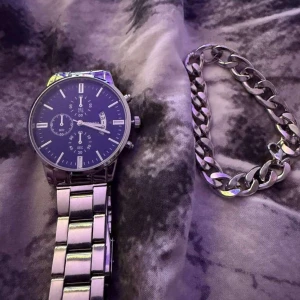 Silverfärgad herrklocka med blå urtavla - Stilren klocka från Geneva med blå urtavla och silverfärgad länk i metall. Klockan har tre mindre urtavlor, datumvisning och tydliga vita markeringar. Perfekt accessoar för dig som gillar klassisk design.