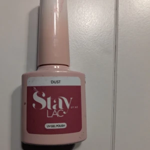 Stay Lac UV Gel Polish Dust - UV gel polish i nyansen Dust från Stay Lac. Kommer i en ljusrosa flaska med vitt och rosa etikett. Innehåller 5 ml och appliceras med pensel. Perfekt för att skapa snygga naglar med salongskänsla hemma.