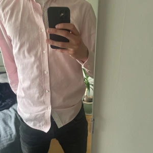 Ljusrosa skjorta - Säljer en stilren ljusrosa skjorta med klassisk krage. Nice för dig som gillar en clean och fräsch look.