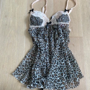 Leopardmönstrad spetslinnetopp från Victoria's Secret - Säljer en as snygg leopardmönstrad linne-topp från Victoria's Secret med ljusrosa spetsdetaljer och svarta rosetter. Tunt och stretchigt luftigt material, Justerbara axelband för bästa passform. Säljer då den inte längre är min stil💓xs