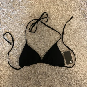 Svart halterneck bikini - Svart halterneck bikiniöverdel från lager 157. Klassisk trekantsform med tunna knytband i nacken och ryggen. Perfekt för sommaren. Skriv gärna om du har frågor o läs helst min bio innan du köper🫶🏻🫶🏻