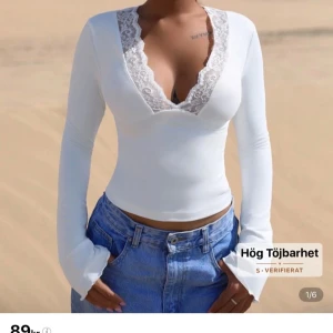 Vit långärmad topp med spetsdetalj - Säljer en vit långärmad topp med djup v-ringning och fina spetsdetaljer runt halsen. Toppen är tight och har hög töjbarhet. Helt ny endast provad, köpte från Shein men kunde inte skicka tillbaka så säljer den nu. 