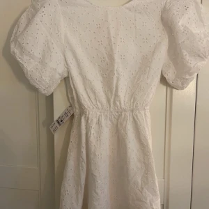 Vit broderad klänning med puffärm - Superfin vit klänning med broderade blommor och puffiga kortärmar. Från Gina Tricot. Aldrig använd med prislapp kvar.