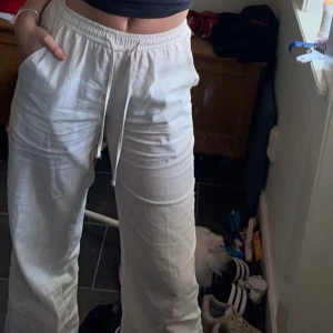 Vita linnebyxor - Säljer ett par vita linnebyxor med avslappnad passform och elastisk midja med snörning. Byxorna har raka ben och är perfekta för varmare dagar. Superbekväma och lätta att styla till olika outfits. Byxorna är i storlek xs/regular, alltså regular längd på byxan. Byxorna är också  mid to low waist☺️