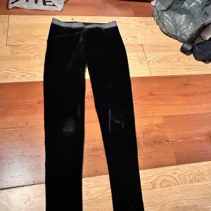 Svarta sammetsleggings från Peppers - Säljer ett par svarta leggings i mjuk sammet från Peppers. De har en elastisk midja och sitter tight längs benen. Perfekta för dig som vill ha något bekvämt men ändå stilrent.