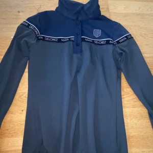 Mörkblå långärmad tröja från Maya Delorez - Säljer en mörkblå långärmad tröja från Maya Delorez ( ridtröja ) . Väldigt skönt material och stretchigt!! 💕 ( Äkta)
