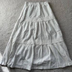 Vit långkjol från Mango - Säljer en vit långkjol från mango med volangdetaljer och resår i midjan. Storlek XXS. Hör av er vid frågor 🩷 säljer då den är för liten