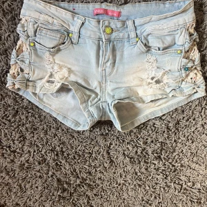 Ljusblå jeansshorts  - Supersnygga lågmidjade jeansshorts! Köpt second hand! Pris kan diskuteras Midjemått: 34cm Längd fram :19cm Längd bak:20 Grenmått: 17 skriv för mer frågor!