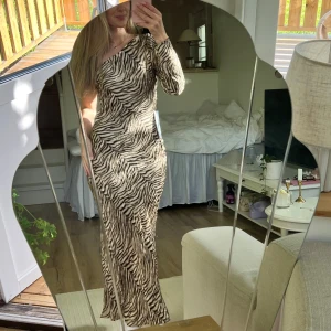 Långklänning - Tigermönstrad långklänning från ASOS i ett sååånt fint material🧡🐅 Faller jättesnyggt! I storlek 34,  och på mig som är 160cm går den ner till fötterna!😚 Den är aldrig använd & lappen är kvar! (Har även en likadan i storlek 36 som jag också säljer!)