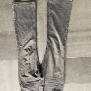 Grå jeansbyxor med raka ben - Säljer ett par grå jeansbyxor med klassisk femficksdesign och raka ben. Byxorna har normal passform och är tillverkade i denim. Perfekta för en avslappnad stil.