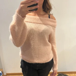 Ljusrosa offshoulder stickad tröja från Gina Tricot - Supermjuk och fluffig ljusrosa stickad tröja från Gina Tricot. Offshoulder-modell med bred krage och långa ärmar. Perfekt för lager-på-lager och en snygg detalj till din outfit.