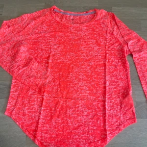 Rosa långärmad träningströja från H&M - Säljer en rosa långärmad träningströja från H&M. Tröjan har ett melerat mönster och är tillverkad i ett lätt och syntetiskt material som andas. Perfekt för träning eller en aktiv vardag.