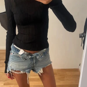 Ljusblå slitna jeansshorts från Zara - Säljer ett par ljusblå jeansshorts från Zara med råa, fransiga kanter och slitningar framtill. Klassisk femficksmodell med låg midja och knappgylf. Perfekta för sommaren!