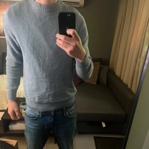 Ljusblå stickad tröja från Dobber - Säljer en ljusblå stickad tröja från Dobber i storlek S. Tröjan har rund halsringning, långa ärmar och ribbade muddar vid ärmslut, hals och nederkant. Perfekt för lager-på-lager och enkel att matcha med jeans.