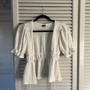 blus  - går att knyta med snören eller ha öppen med ett linne under 