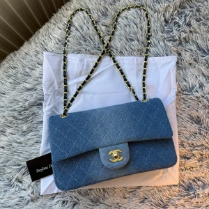 Chanel Classic Flap Bag DENIM - Denna specifika denimväska från Chanel finns inte kvar i butik. Den släpptes som en begränsad utgåva och har utgått ur produktion.      🔊Pris kan diskuteras 🔊 Detaljer * indigoblå * tvättad denim * diamantquiltning * märkets kännetecknande vridlås med Interlocking CC-motiv fram * axelrem i läder med kedjelänk * viklock * utanpåliggande fack baktill * huvudfack * innerfack med dragkedja * innerfack * stämplad logotyp på insidan * helfodrad design