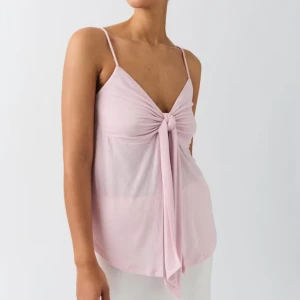 Ljusrosa linnetopp med knyt från Gina tricot - Supersöt ljusrosa linnetopp från Gina med smala axelband och knyt framtill. Toppen är ärmlös och har en luftig, flowy passform som passar perfekt till sommaren. Materialet är mjukt och lätt.
