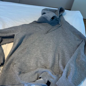 Grå hoodie med huva - Säljer en enkel och stilren grå hoodie med huva och magficka. Perfekt för chill dagar eller när du vill ha något bekvämt. 