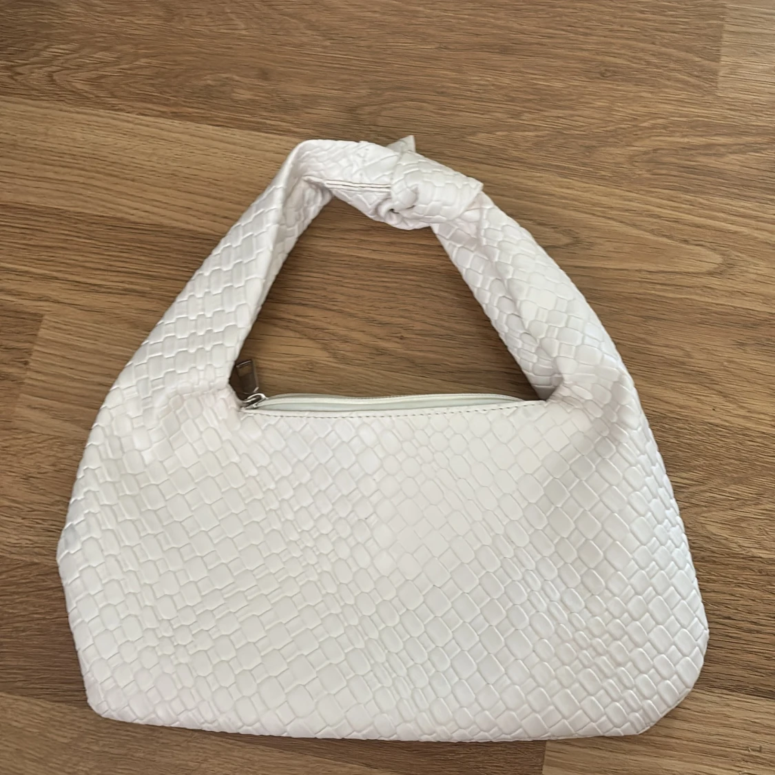 Vit axelväska med knut och ormmönster