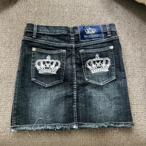  jeanskjol från Victoria Beckham for Rock & Republic - Midjemått är 34 cm bred, kjolen är 37 cm lång, går och syr upp ifall man önskar kortare💓Cool blåa jeanskjol med slitna kanter och två bakfickor med broderade kronor i vitt. Klassisk femficksmodell med silverfärgade nitar och knapp. Perfekt för dig som gillar streetstyle och detaljer med edge.