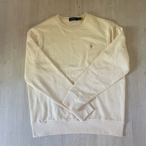 Polo Ralph Lauren || Loopback Fleece  - Säljer en stilren vit Loopback Fleece sweatshirt  från Polo Ralph Lauren med klassisk rund halsringning och broderad logga på bröstet. Tröjan har långa ärmar och är perfekt för en avslappnad och snygg look.