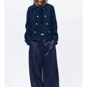 Mörkblå jeansjacka med guldknappar - Snygg mörkblå jeansjacka med dekorativa guldknappar. Jackan har klassisk krage och raka ärmar. Har kommit till användning vid ett tillfälle och säljer då jag inte använder den. Köptes på Zara för 659 kr och mitt pris är 500 kr🩷