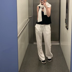 Vita linnebyxor Lågmidjade  - Säljer ett par vita linnebyxor med avslappnad passform och dragsko i midjan. Byxorna har raka ben och är perfekta för varma dagar. Stilrena och lätta att matcha med olika toppar. Säljer pga av att jag växt ur dem 