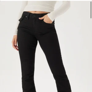 Svarta bootcut jeans från True Religion - Säljer ett par svarta jeans från True Religion med bootcut-passform. Byxorna har klassiska fickor med lock och knapp bak, samt detaljerade sömmar. Tillverkade i jeansmaterial och har normal passform med låg midja. Midjemått: 34cm Innerbenslängd: 81,5cm