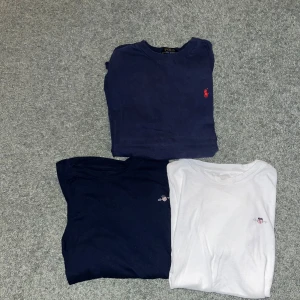 Två mörkblå och en vit t-shirt från Polo Ralph Lauren - Tre klassiska T-shirts varav 2 från gant och 1 från Ralph lauren. Ralph lauren tröjan har ett hål i båda armhålorna, 150 kr för Ralph lauren T-shirt. Can’t T-shirts är i ett bra skick och säljs därför för 200kr för båda. 350 kr för alla t- shirts. Skulle kunna få bättre erbjudande om man köper alla på en gång alltså snabb affär.