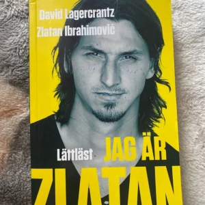 Jag är Zlatan - Boken 'Jag är Zlatan' av David Lagercrantz och Zlatan Ibrahimović är en lättläst biografi med gul och svart framsida. Omslaget har ett porträtt av Zlatan och stora tydliga bokstäver. Perfekt för dig som gillar sport och inspirerande biografier.