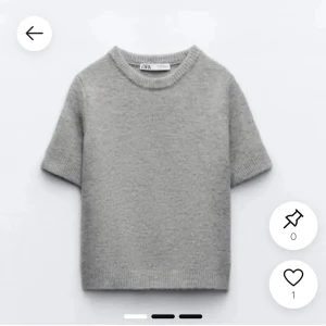 Grå stickad kortärmad tröja från Zara - Säljer en enkel och stilren grå stickad tröja från Zara. Tröjan har korta ärmar, rund halsringning och är gjord i ett mjukt stickat material. Perfekt för lager-på-lager eller som den är.