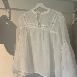 Blus med spets - Jättefin vit blus med spets och snören från H&M. Säljer då den aldrig kommer till användning. Den är aldrig använd, endast testad enstaka gång. Storlek M, normal i storleken. Inköpt för 349kr.