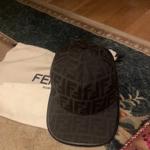 Fendi keps - hej säljer mitt svarta Fendi keps som jag inte längre använder. Kepsen har inga konstigheter den har inga fläckar eller hål osv. Säljer den pågrund av att tänker spara pegar. Kom dm för mera bilder😄Obs Påse och dust bag följer med!