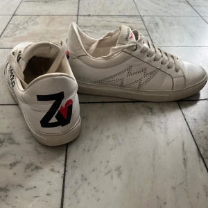 Vita sneakers från Zadig & Voltaire - Säljer dessa jätte fina vita sneakers från Zadig & Voltaire. De är i bra skick då jag inte har använt dom så mycket. Köptes på farfetch för 2800 kr🥰Är i storlek 41 men passar även mig perfekt som har 40 i vanliga fall❤️