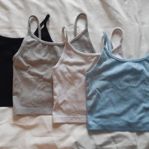 4 st ribbade linne-toppar från FB Sister - Säljer ett 4-pack ribbade linne-toppar från FB Sister i färgerna svart, grå, vit och ljusblå. Perfekta att matcha till olika outfits. Alla har smala axelband och är i stretchigt material.