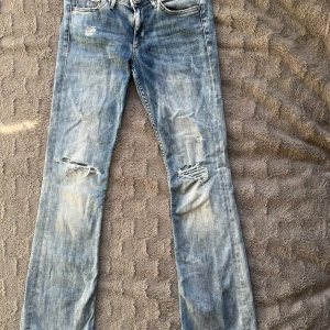 Blå bootcut jeans med slitningar - Snygga lågmidja flare blå jeans från &Denim med slitningar. Storlek 27/30 eller XS/S.