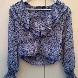 Zara blus - Blå Zara blus, kortare vid magen med fint mönster