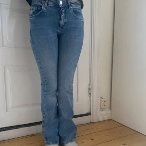 Ljusblå bootcut jeans - Säljer ett par ljusblå jeans med bootcut-modell och klassisk femficksdesign. Jeansen har normal passform och är tillverkade i denim med lätt stretch. Perfekta för dig som gillar en tidlös look med lite utsvängda ben. Från Kappahl men blivit för små