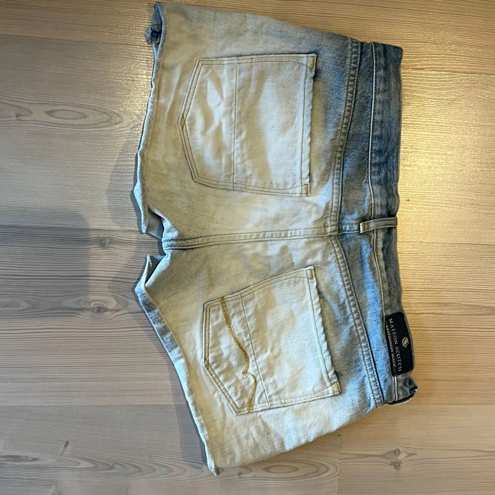 Säljer ett par ljusblå jeansshorts från Maison Scotch. Shortsen har normal passform och är perfekta för varma dagar. Snygg Maison Scotch-lapp bak i midjan. Storlek w27 passar som s/m.. Shortsit.