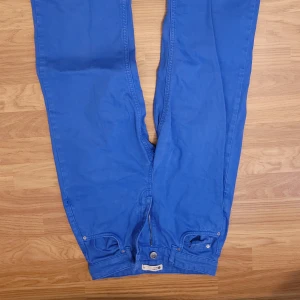 Blå jeans med raka ben - Snygga blå jeans med raka ben och klassiska fickor både fram och bak. Byxorna har knapp och dragkedja i gylfen och är perfekta för en avslappnad men stilren look.