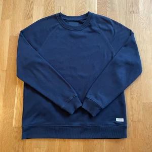 Mörkblå sweatshirt  - Säljer en stilren mörkblå sweatshirt från lager 157. Tröjan är knappt använd och har inga skavanker. Perfekt för en avslappnad och enkel look.