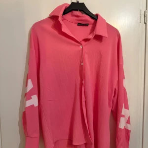 Rosa oversized skjorta  - Skjortan har klassisk krage, knäppning framtill och långa ärmar. Perfekt för en trendig och avslappnad look. Inget fel, säljer pga ingen användning 