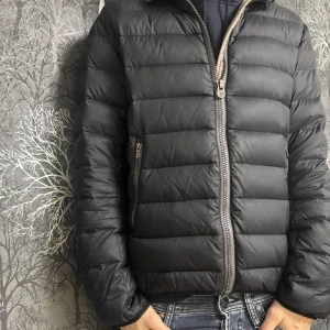 Colmar Jacka - Säljer en svart dunjacka från Colmar med huva och dragkedja. Jackan är perfekt för kyligare väder. Det märks att jackan är använd därav de billigare priset. OBS höger ficka är sönder eftersom dragkedjan är paj. Hör av dig om du är intresserad eller har några frågor MVH