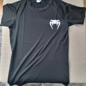Svart t-shirt med tryck - Svart t-shirt med coolt vitt tryck på bröstet och ryggen. Perfekt för en avslappnad stil. Tillverkad i ett mjukt och bekvämt material.