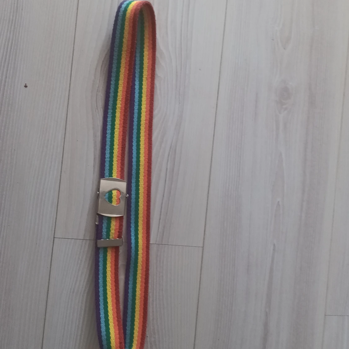Regnbågsfärgat bälte med hjärtspänne