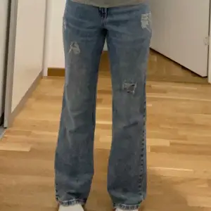 Snygga blå flared jeans med slitna detaljer. 